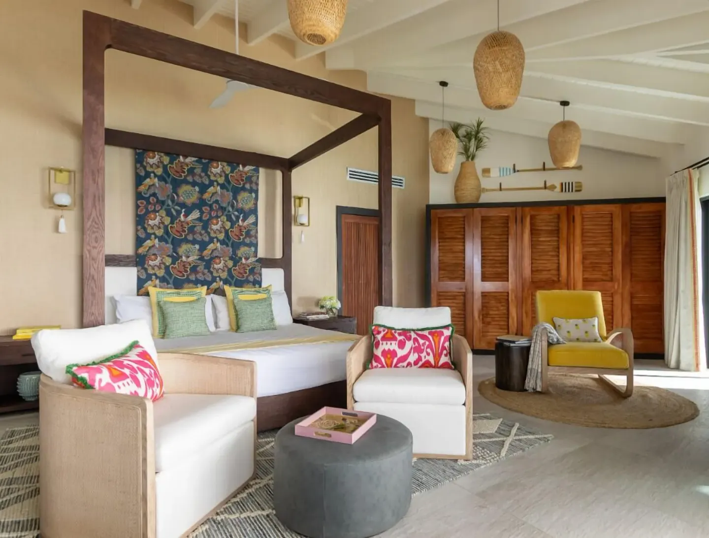 Spacious king bed guest room with lounge chairs at Tamarind Hills Resort & Villas.