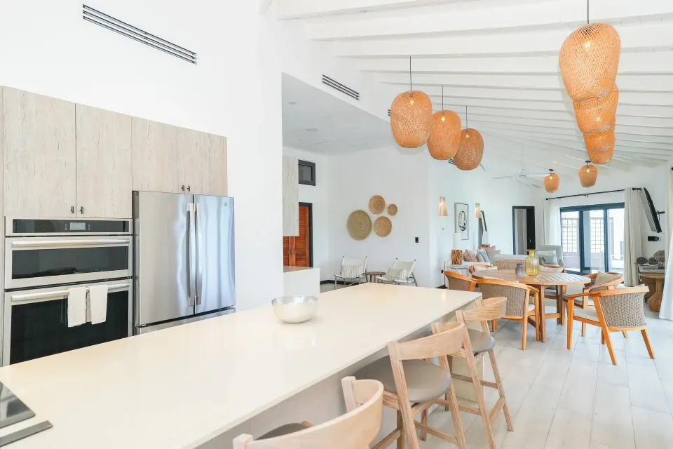 Ocean 19 kitchen island and dining area under woven lights at Tamarind Hills Resort & Villas.