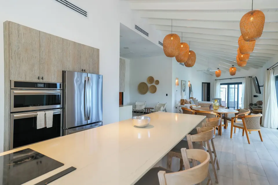 Ocean 19 open kitchen and dining space with lounge beyond at Tamarind Hills Resort & Villas.