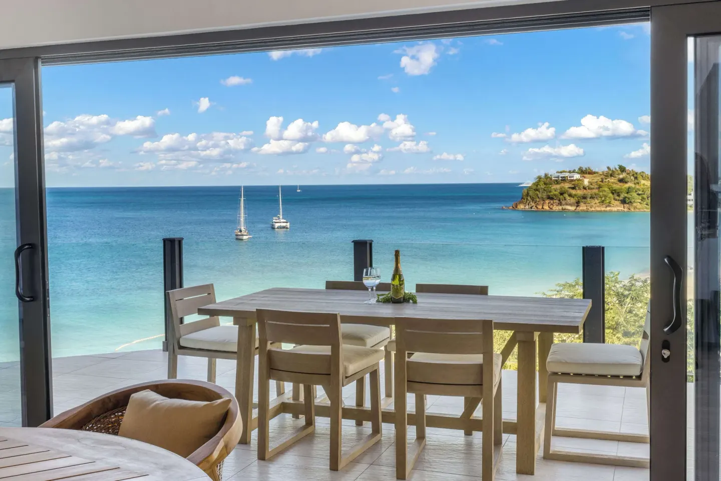 Ocean-view balcony dining area in Room 19 at Tamarind Hills Resort & Villas with turquoise sea beyond.