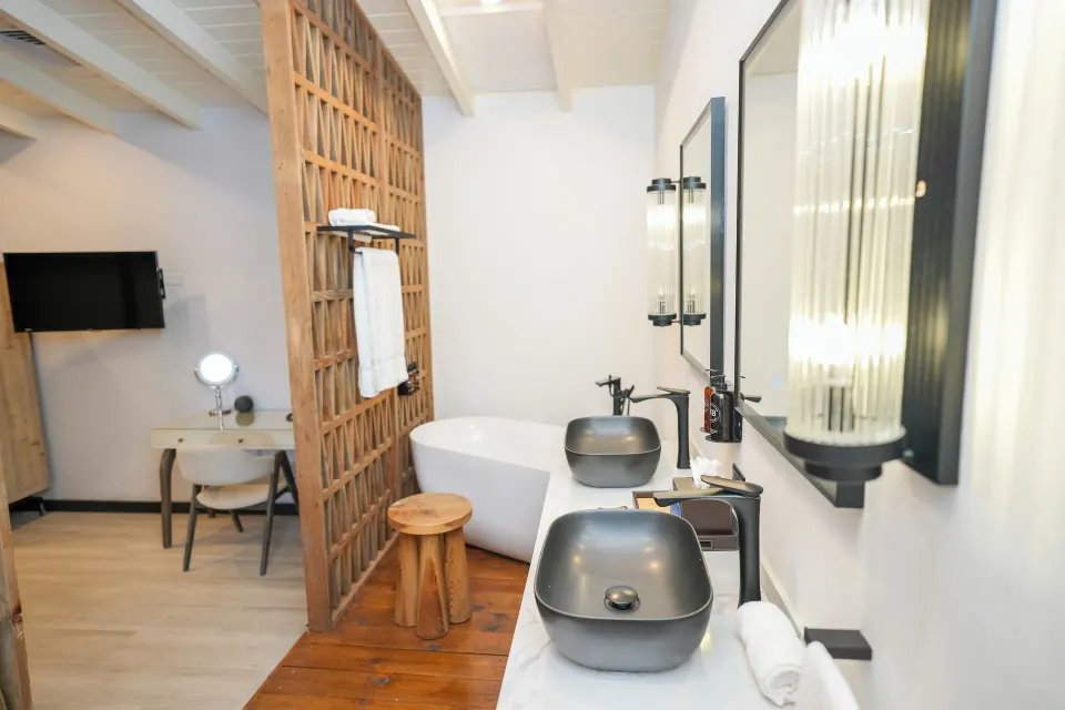 Open bathroom and vanity area in Room 19 at Tamarind Hills Resort & Villas with tub and double sinks.
