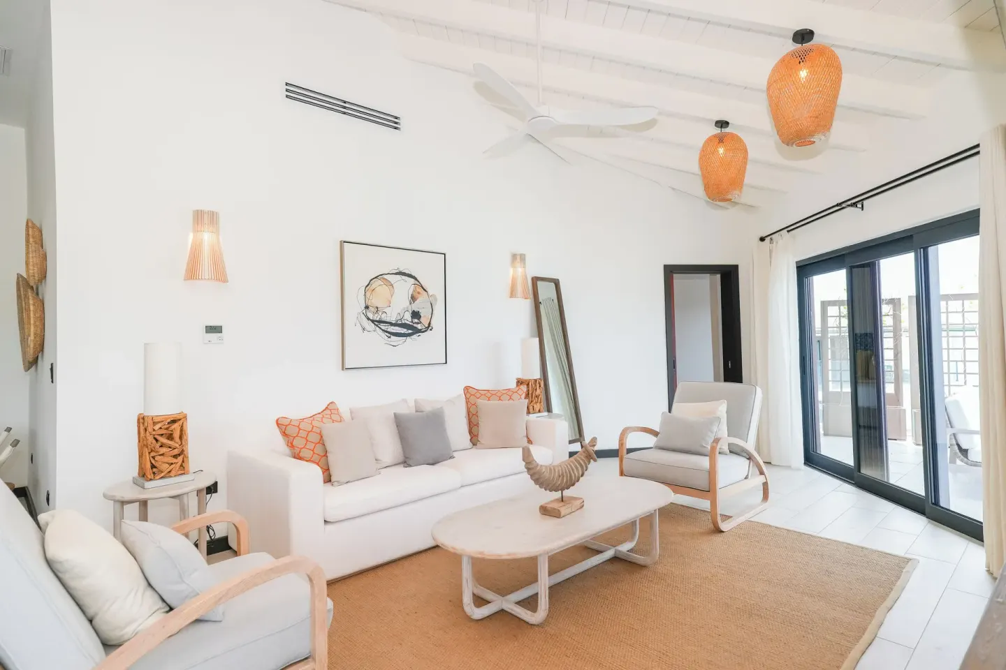 Bright ocean-view living room in Room 19 at Tamarind Hills Resort & Villas with sofa and balcony doors.