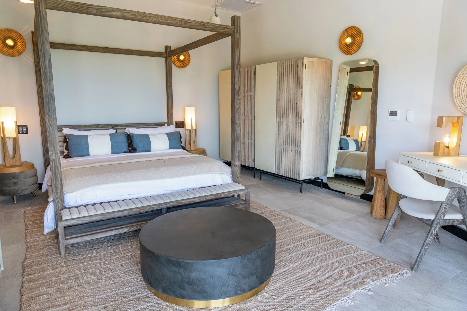Four-poster king bed and vanity in a guest room at Tamarind Hills Resort & Villas.