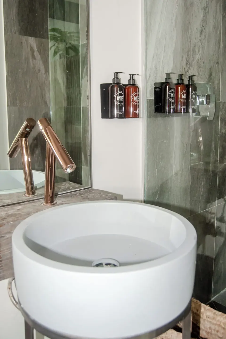 Sunset Vista bathroom sink and glass shower at Tamarind Hills Resort & Villas.