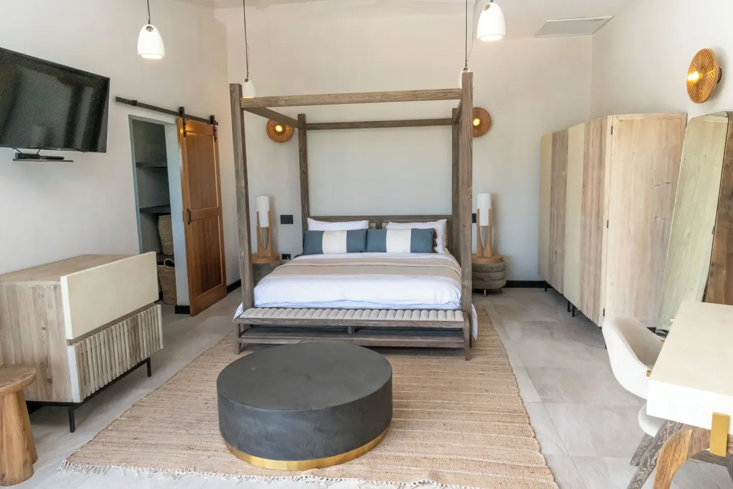 Sunset Vista room bed with TV, wardrobe and desk at Tamarind Hills Resort & Villas.