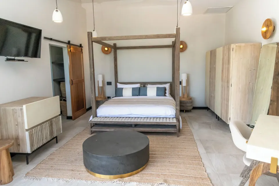 Sunset Vista room bed with TV, wardrobe and desk at Tamarind Hills Resort & Villas.