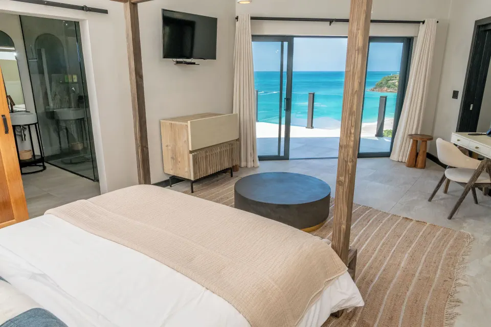 Sunset Vista room with bed, balcony and sea view at Tamarind Hills Resort & Villas.