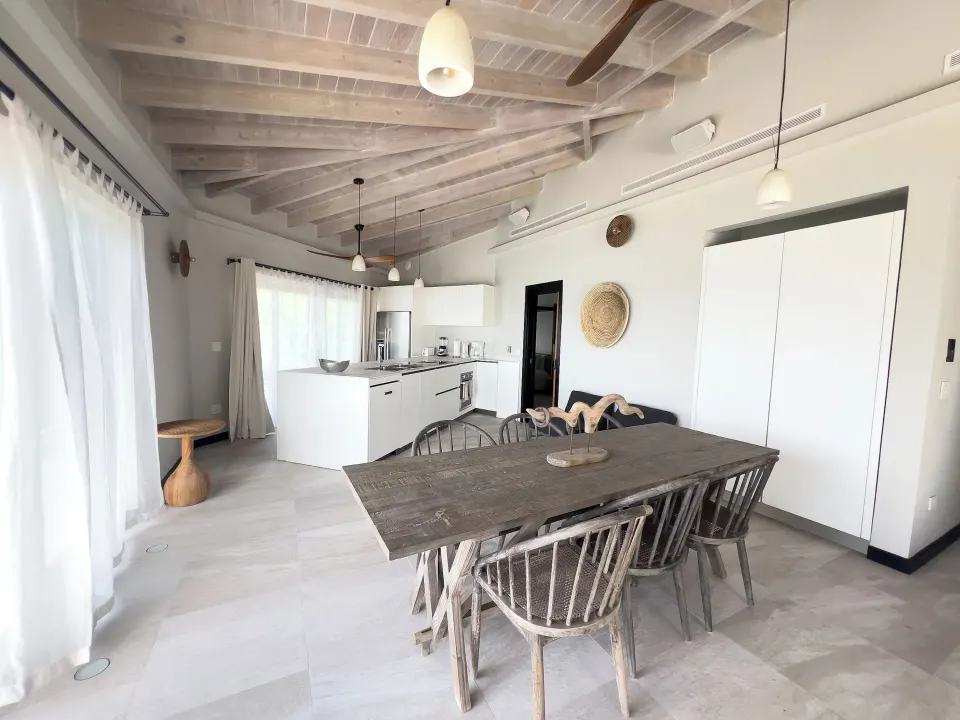 Suite dining area and kitchen at Tamarind Hills Resort & Villas with wood table and vaulted ceiling.