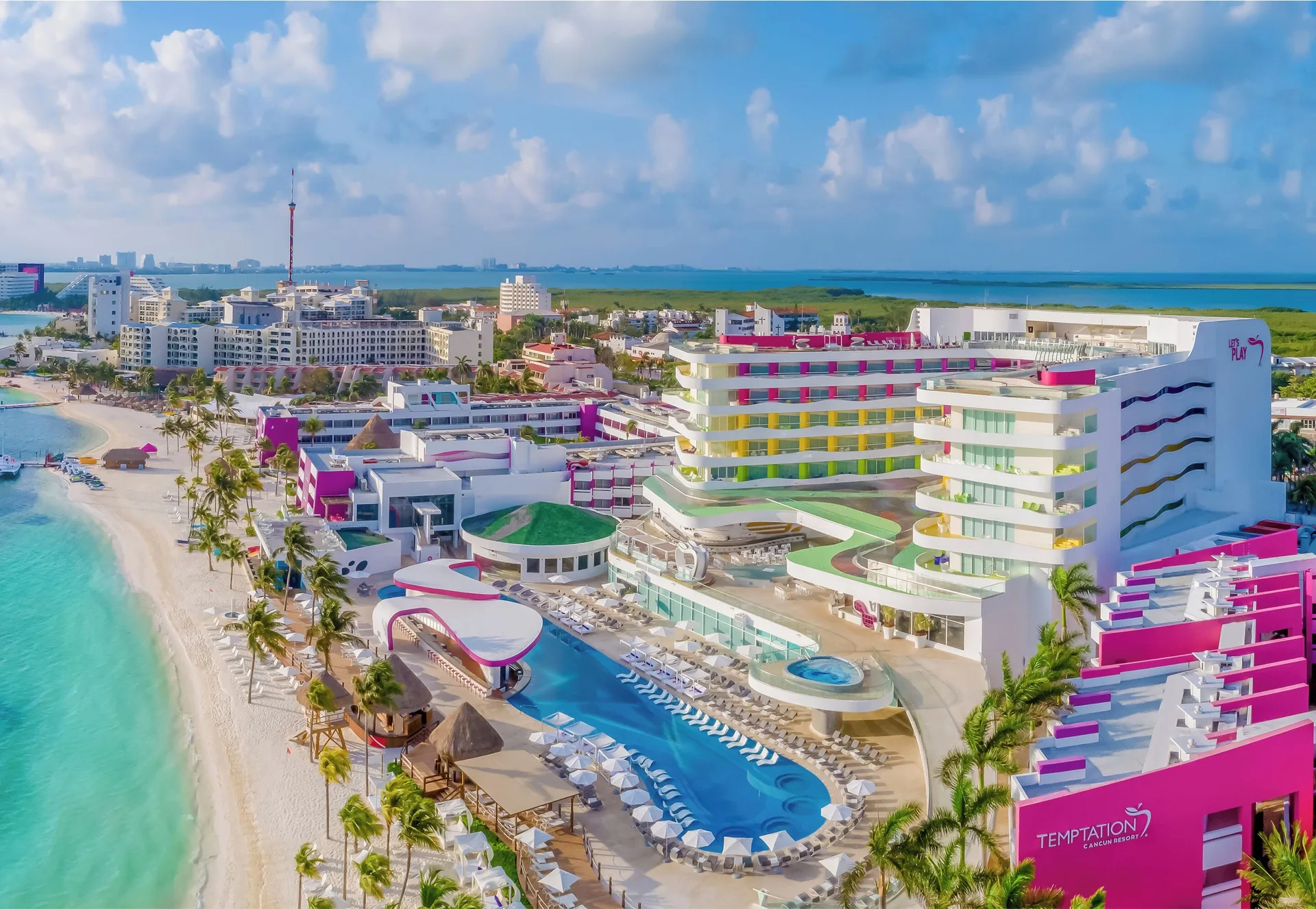 Aerial view of the beachfront pools and colorful tower at Temptation Cancún.
