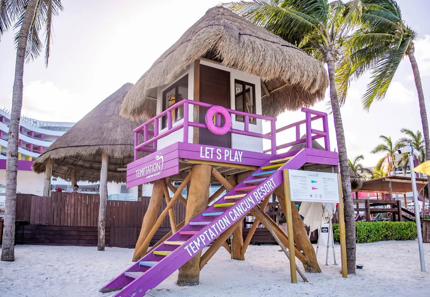 Purple beach lifeguard tower with thatched roof at Temptation Cancún.