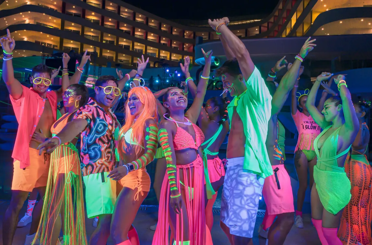 Guests dancing in neon outfits by the pool at Temptation Cancún.