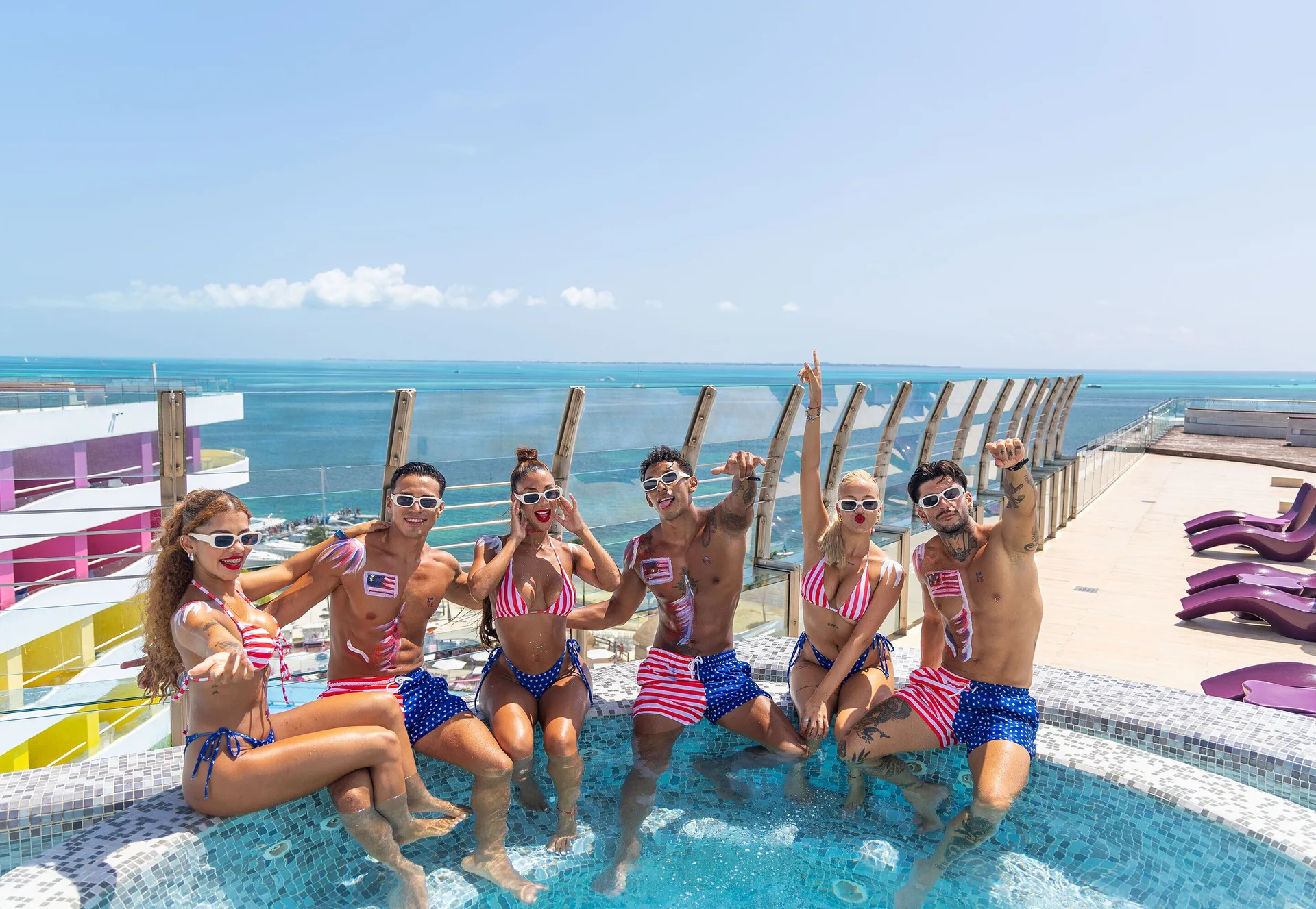 Guests sit in a rooftop hot tub with ocean views at Temptation Cancún.