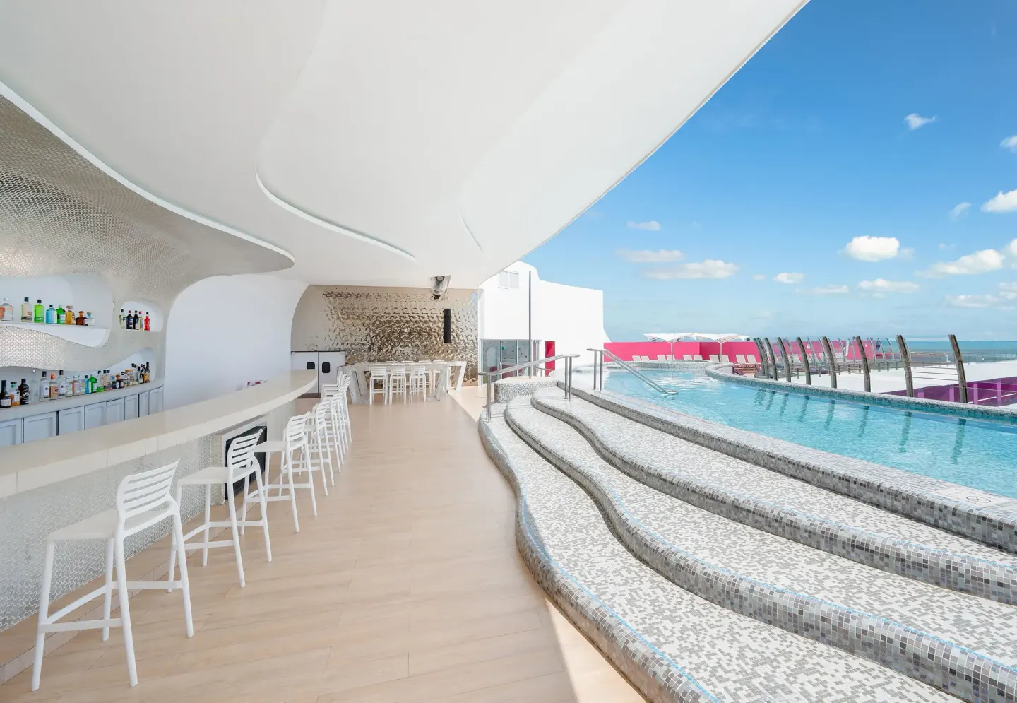 Rooftop pool and white bar with ocean view at Temptation Cancún.
