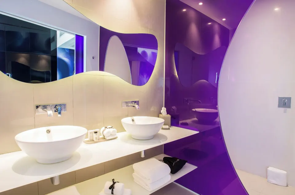 Bash Tower Ocean View bathroom at Temptation Cancún with dual vessel sinks and purple accents.