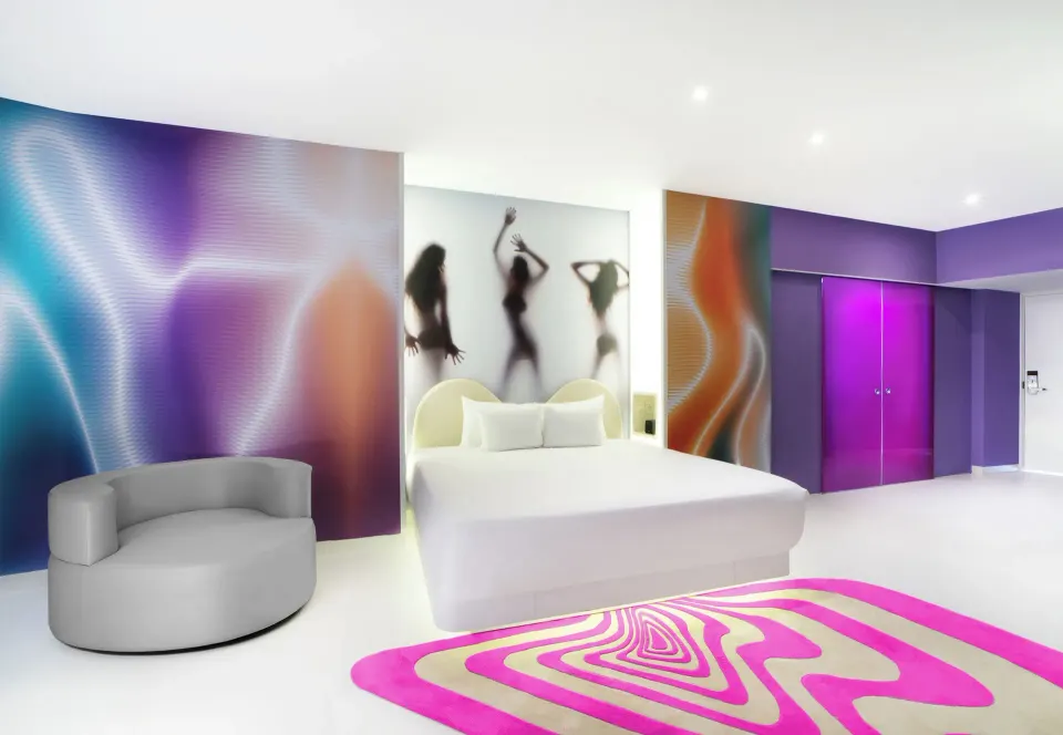 Bash Tower Ocean View king bed room at Temptation Cancún with curved chair and vivid wall art.