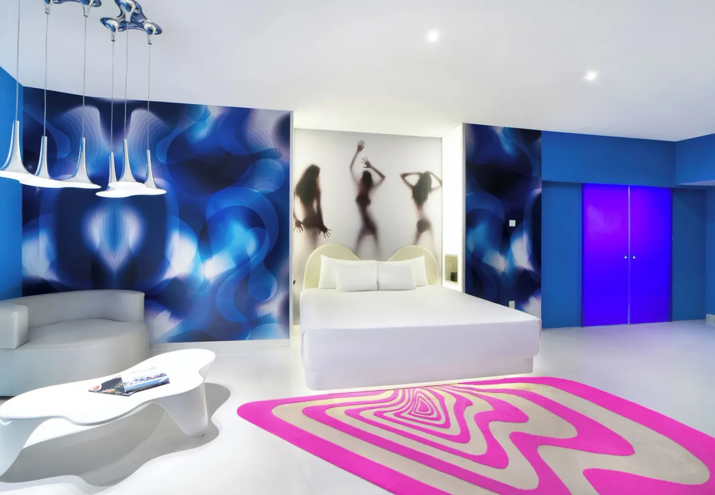 Lush Tower Ocean Front king bed with blue accent walls at Temptation Cancún.