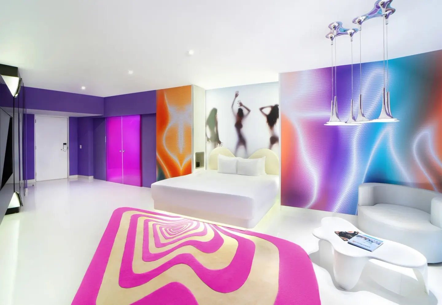 Lush Tower Ocean Front king bed and colorful lounge area at Temptation Cancún.