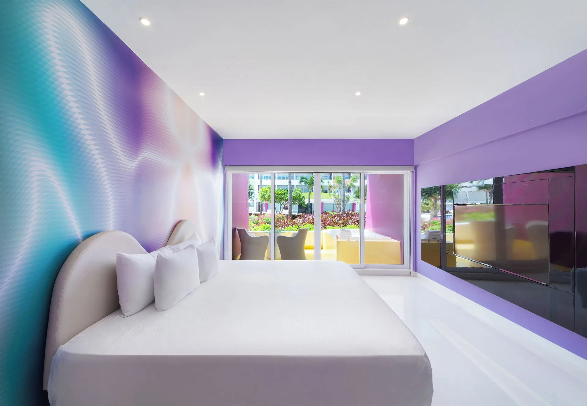 Plush Jacuzzi Ocean View/Garden View room bed facing patio at Temptation at The Tower Cancún.
