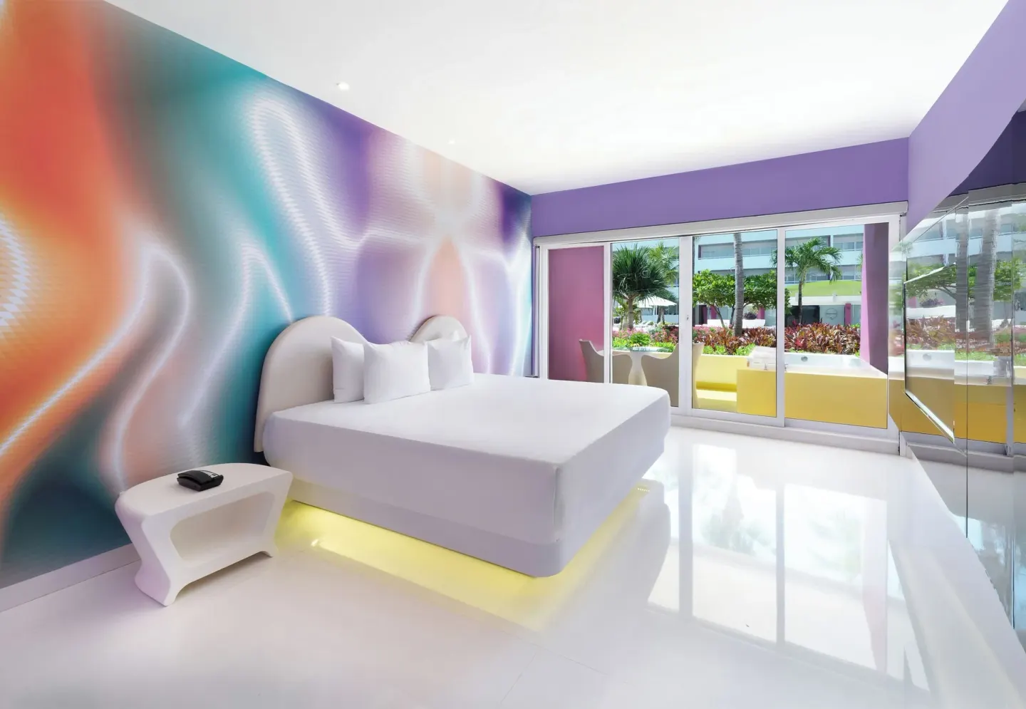 Plush Jacuzzi Ocean View/Garden View room bed and patio at Temptation at The Tower Cancún.