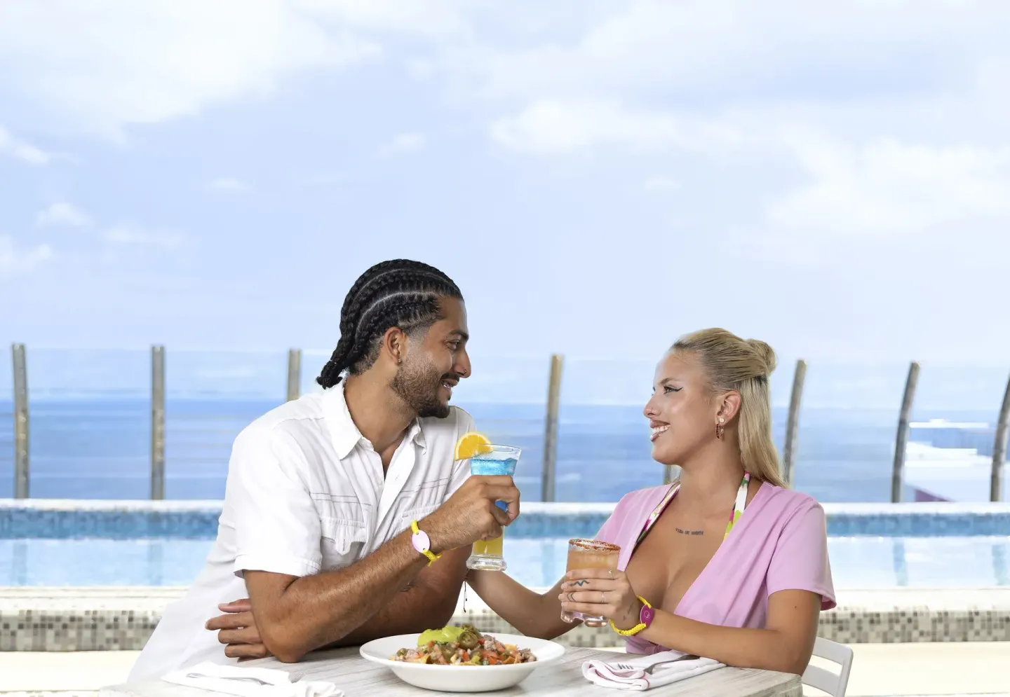 Couple dining by an oceanfront pool at Temptation Cancún.