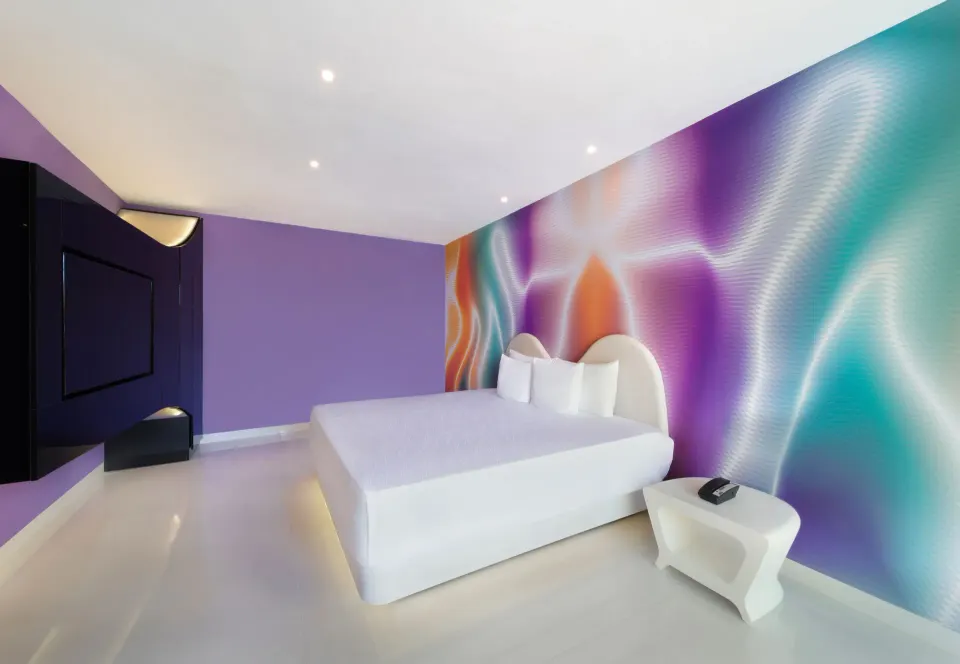 Trendy Room king bed with colorful mural wall at Temptation at The Tower Cancún.