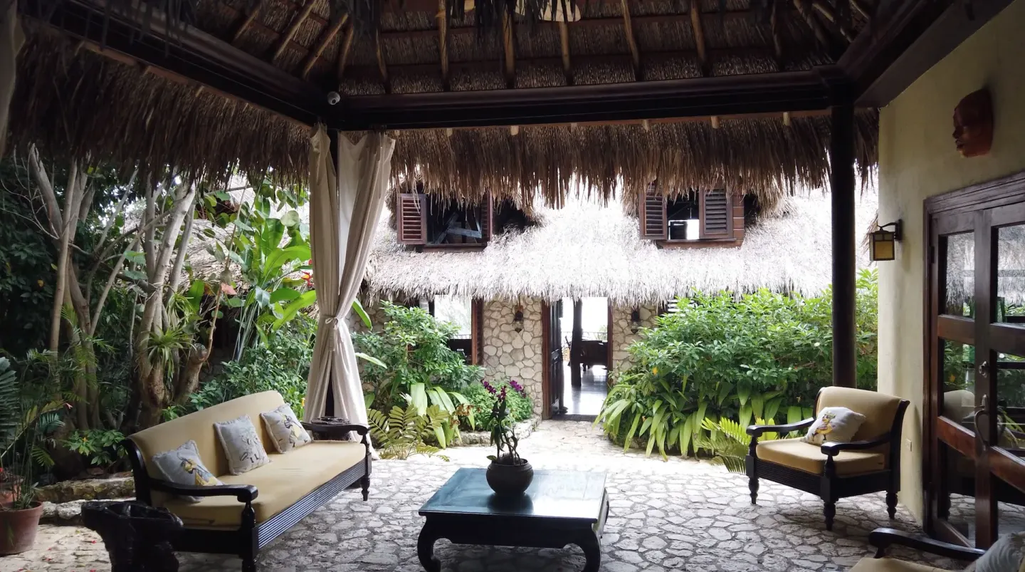 Covered courtyard lounge with sofas and tropical plants at Tensing Pen Hotel.