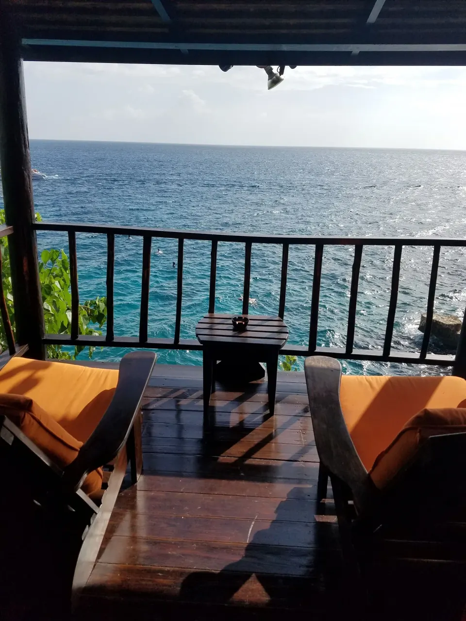 Ocean-facing balcony with two cushioned chairs at Tensing Pen Hotel.