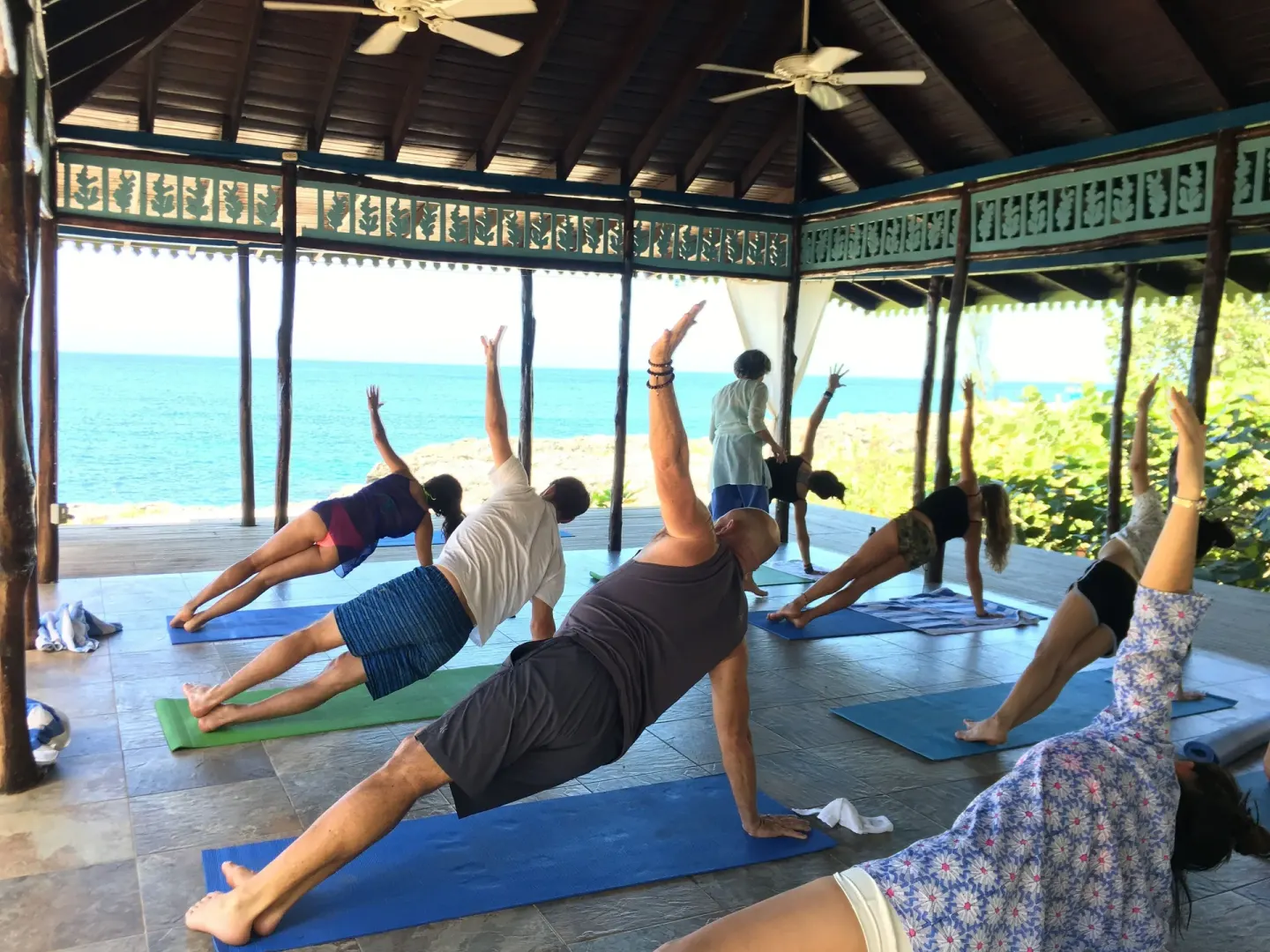 Guests practice yoga in an open-air pavilion facing the sea at Tensing Pen Hotel.