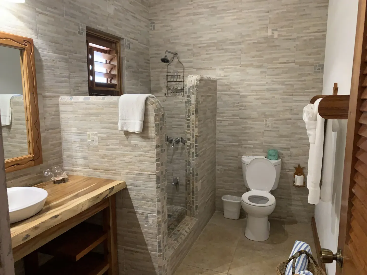 Deluxe Room Ocean View bathroom with tiled shower and wood vanity at Tensing Pen Hotel.