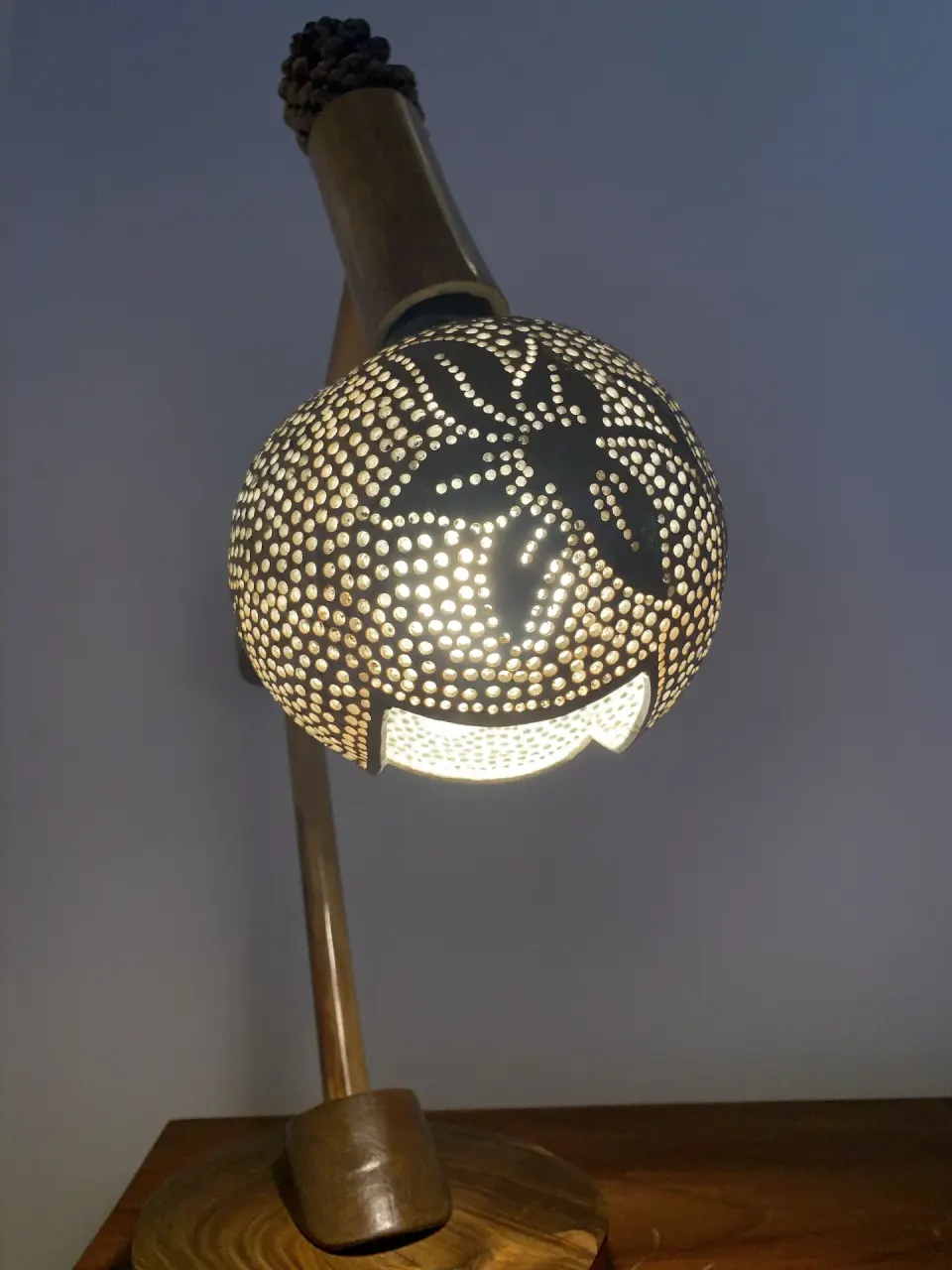 Carved bedside lamp glowing in a Deluxe Room at Tensing Pen Hotel.