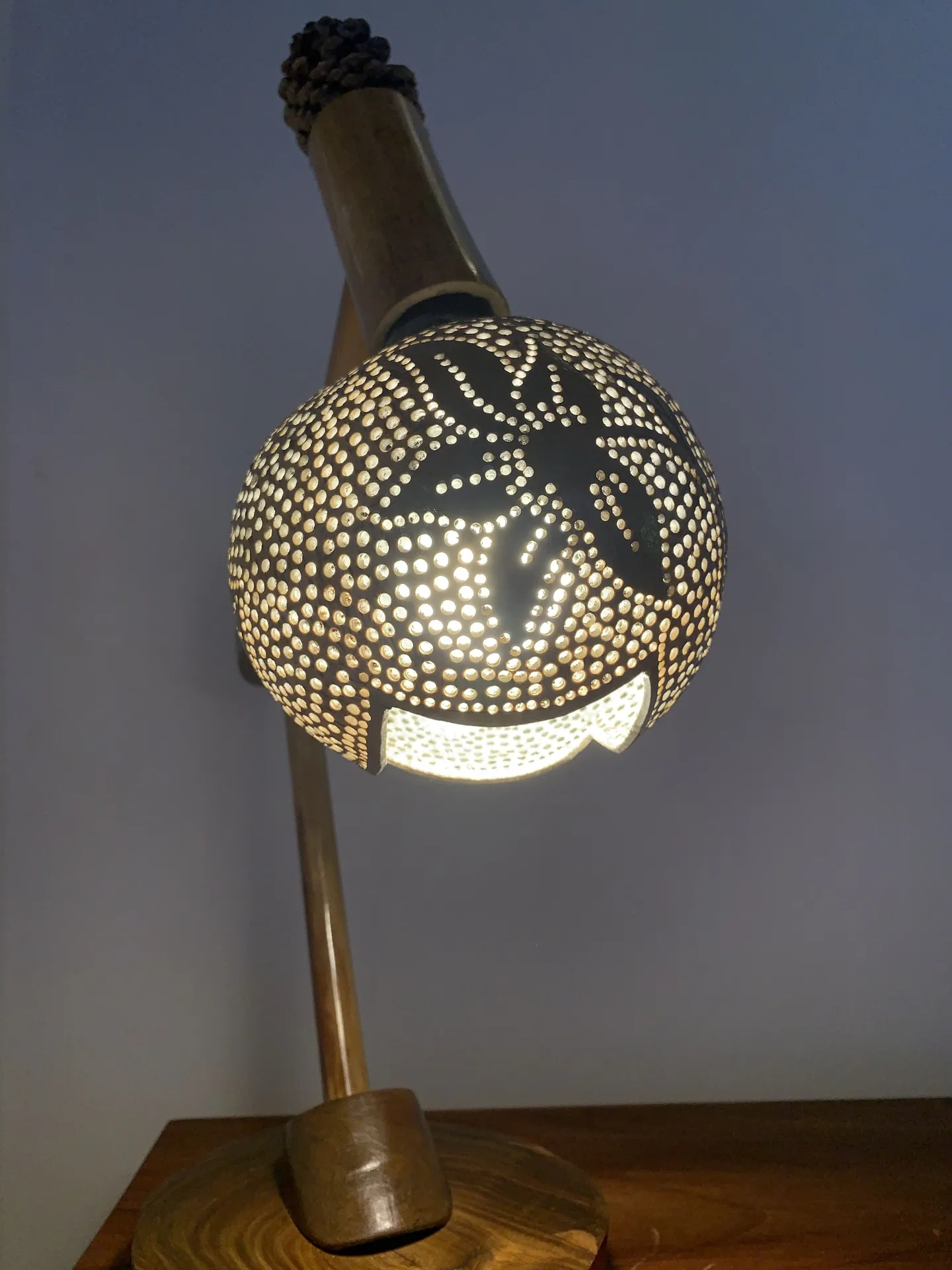 Carved bedside lamp glowing in a Deluxe Room at Tensing Pen Hotel.