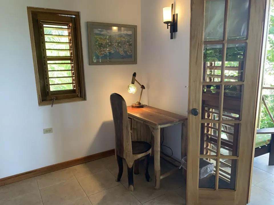 Deluxe Room Ocean View writing desk beside louvered windows at Tensing Pen Hotel.