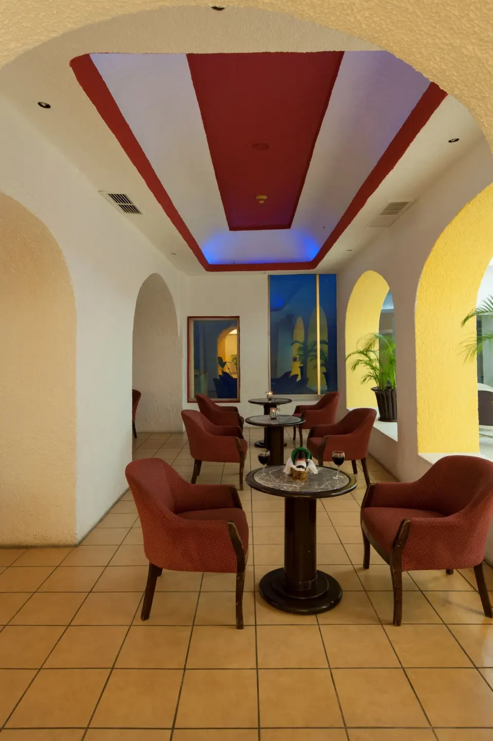Lounge seating with small tables and arched openings at Tesoro Manzanillo.