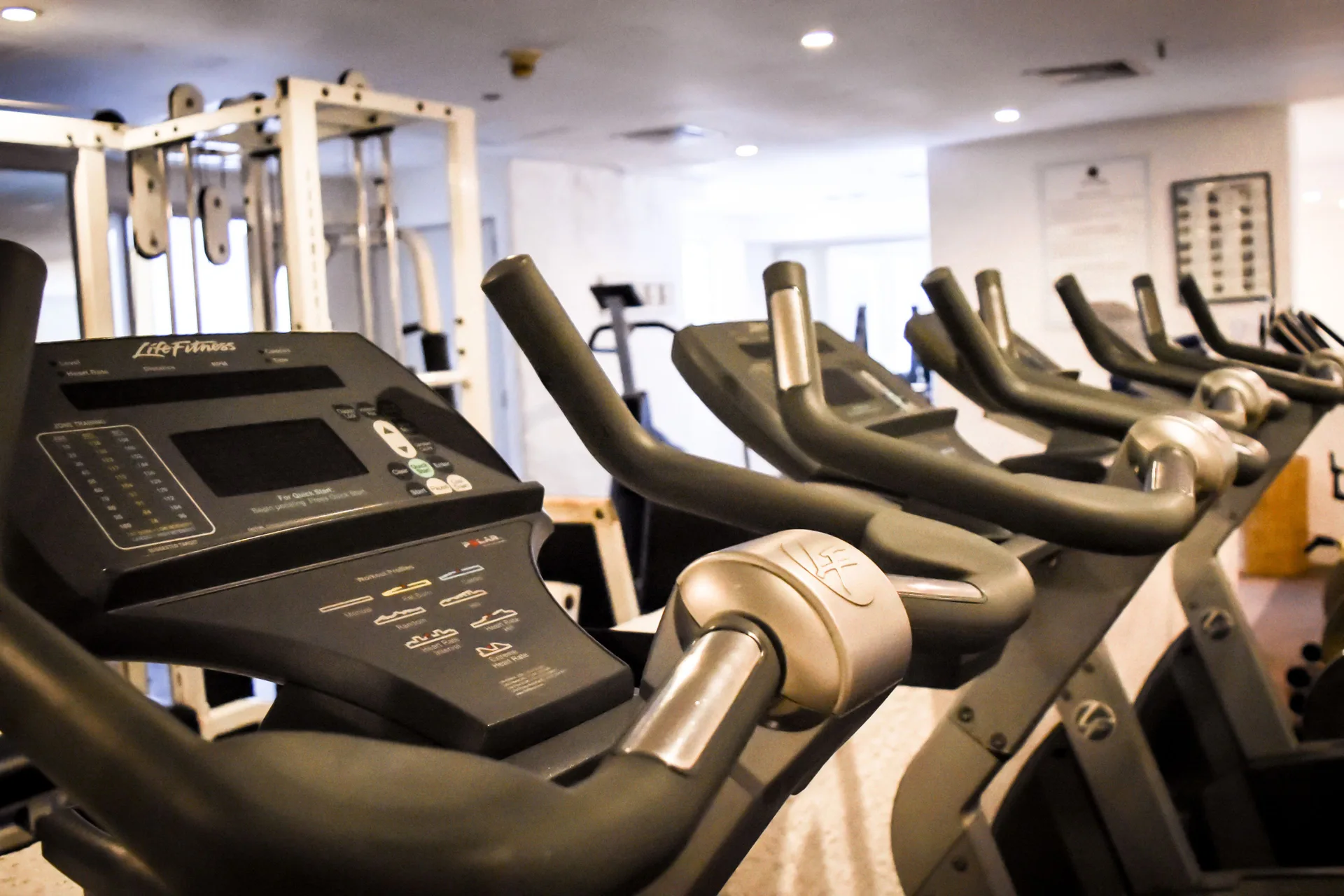 Row of cardio bikes and strength equipment inside the gym at Tesoro Manzanillo.