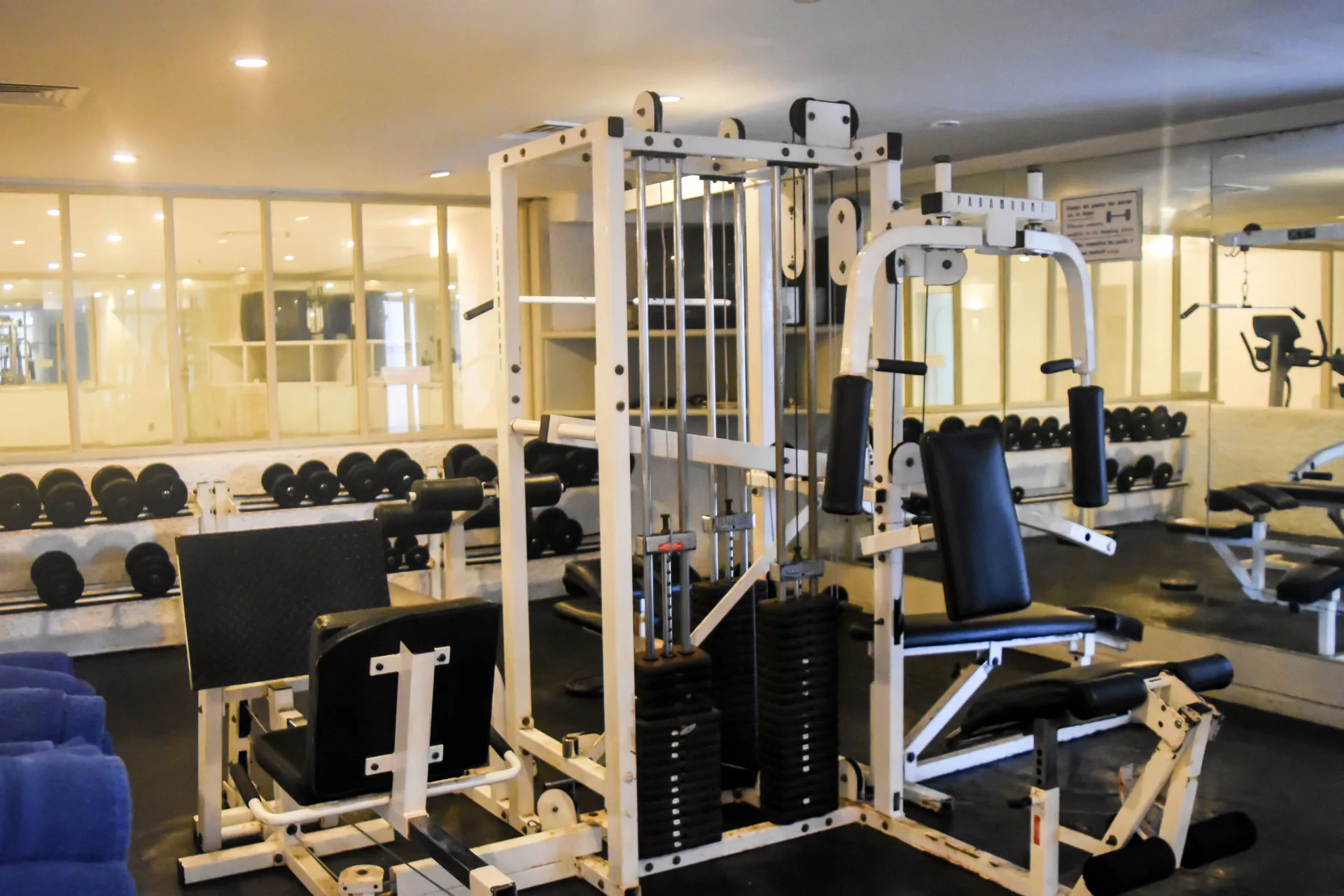 Fitness room with weight machines, benches, dumbbells, and mirrors at Tesoro Manzanillo.