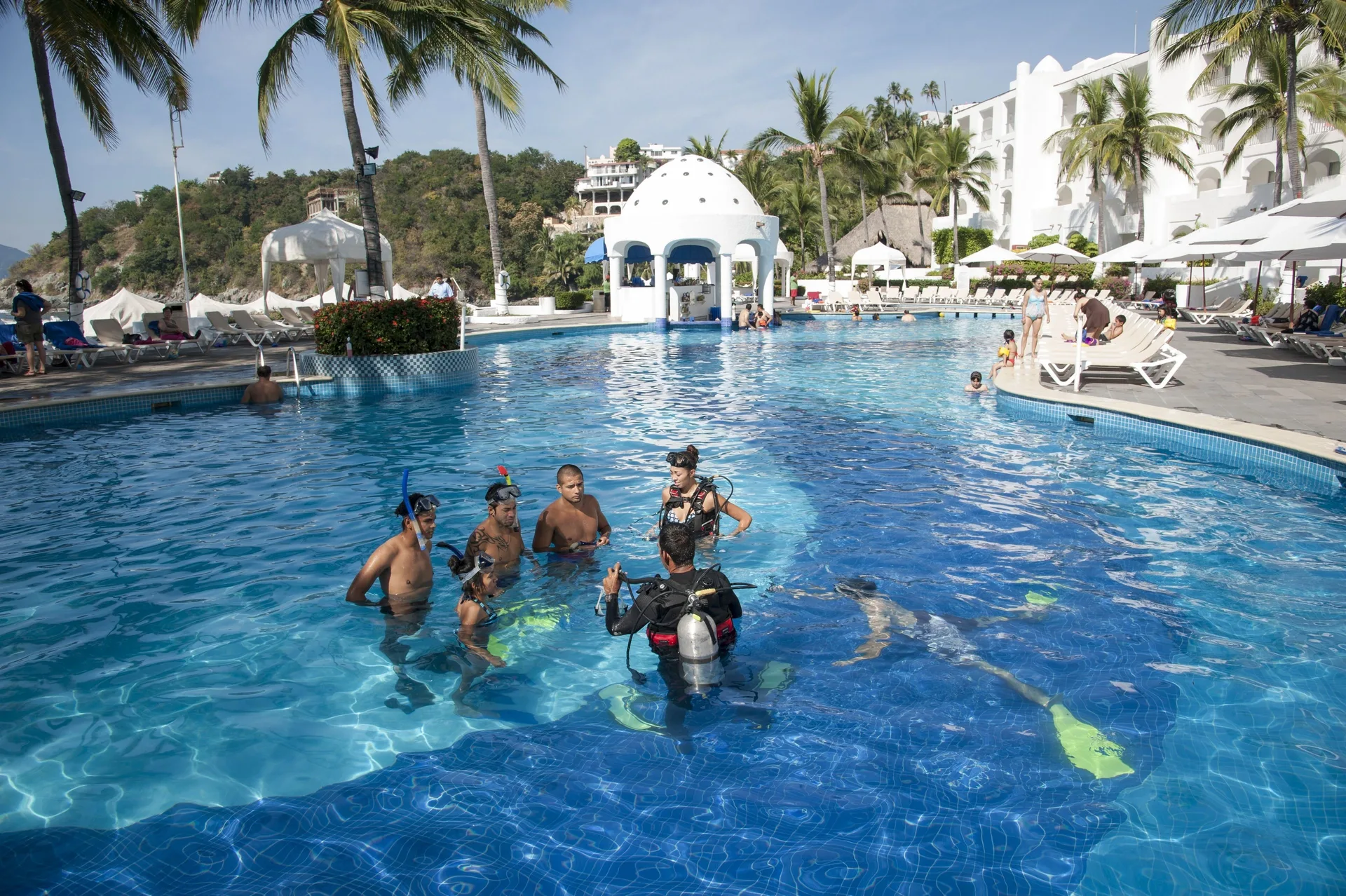 Resort pool with guests and scuba instruction at Tesoro Manzanillo.