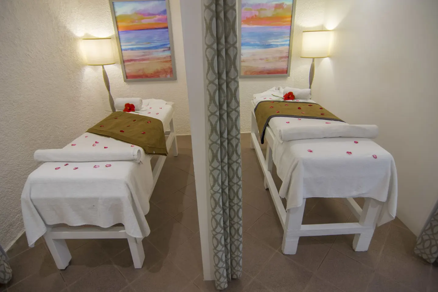 Two spa treatment beds with towels and flower petals at Tesoro Manzanillo.