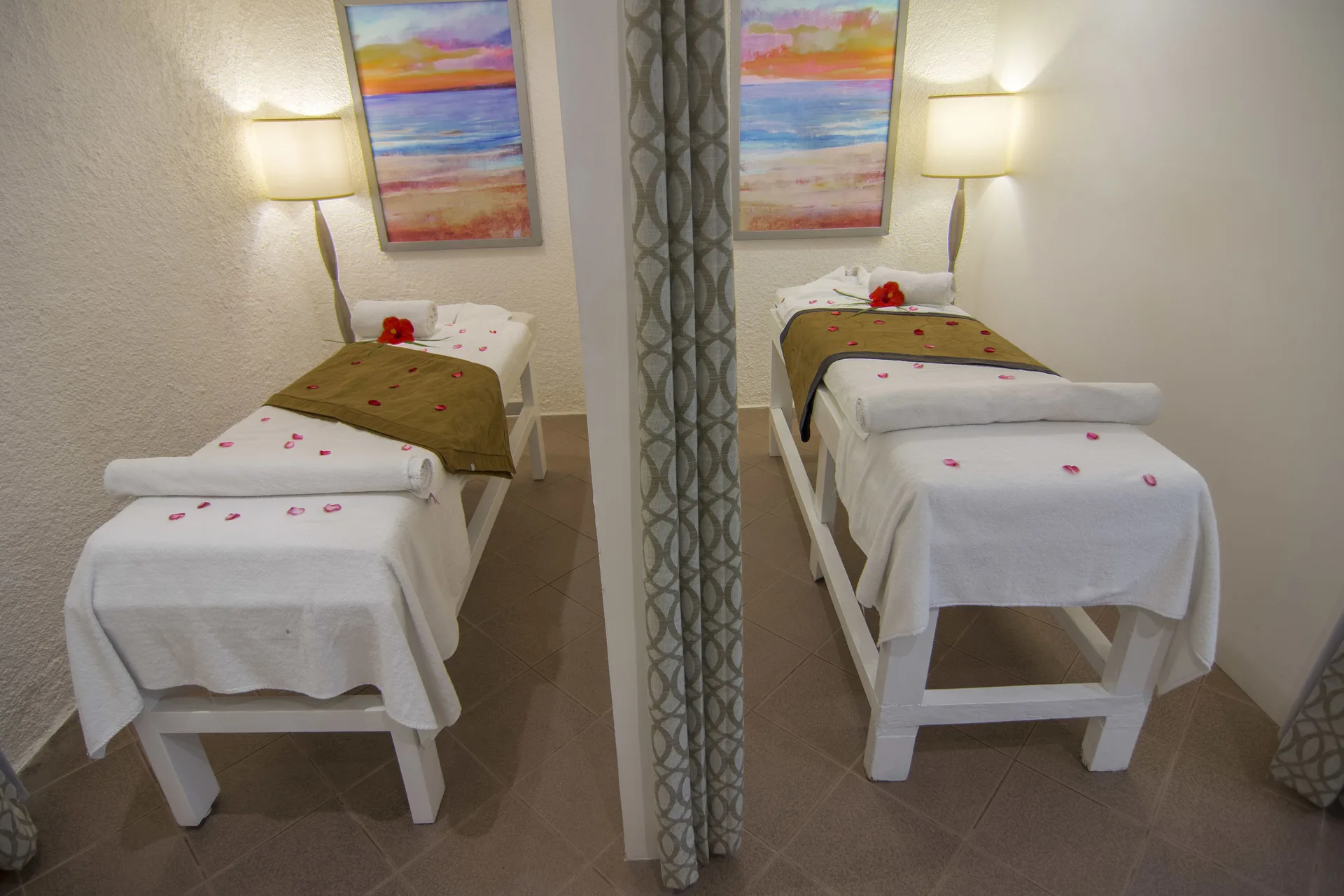 Two spa treatment beds with towels and flower petals at Tesoro Manzanillo.