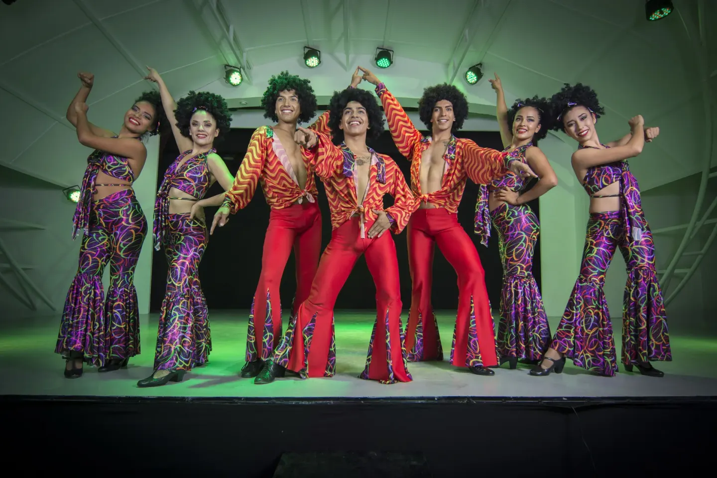 Costumed dancers pose on a lit stage during evening entertainment at Tesoro Manzanillo.
