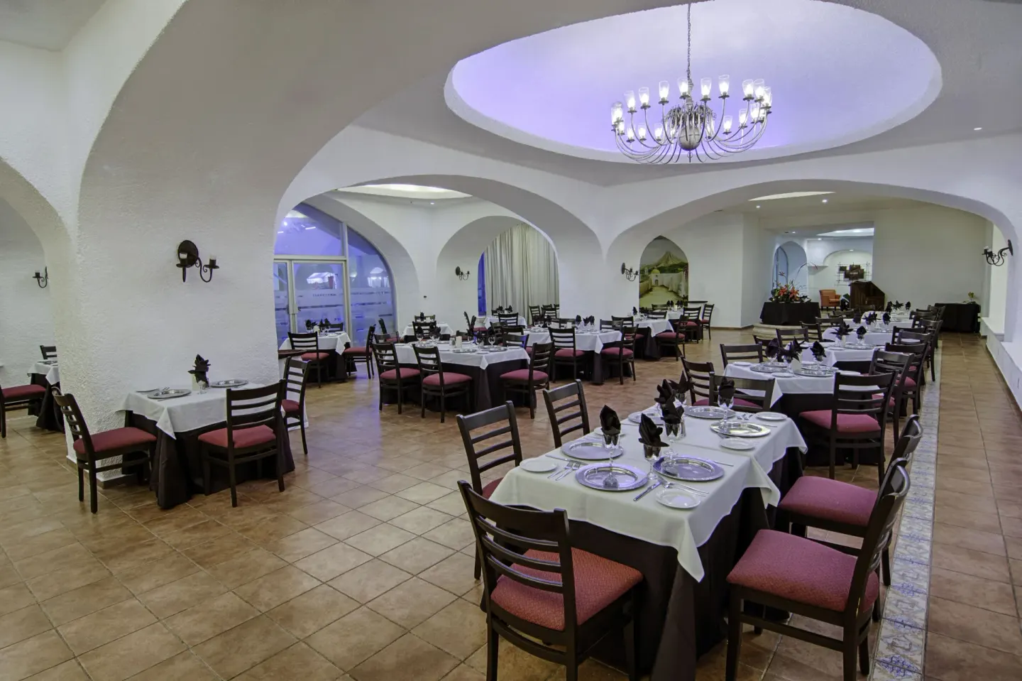 Formal indoor dining room with arched ceilings and a chandelier at Tesoro Manzanillo.