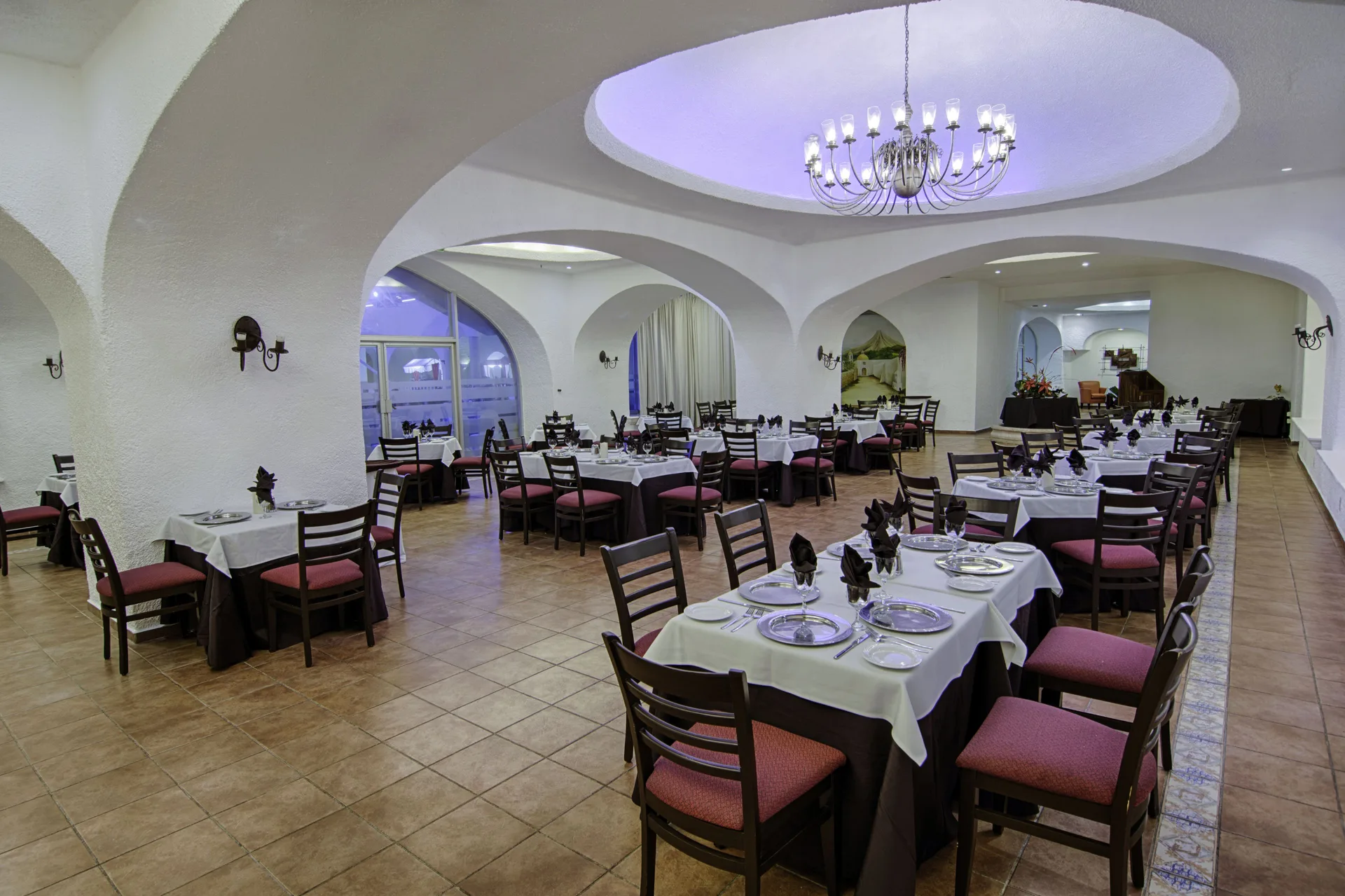 Formal indoor dining room with arched ceilings and a chandelier at Tesoro Manzanillo.