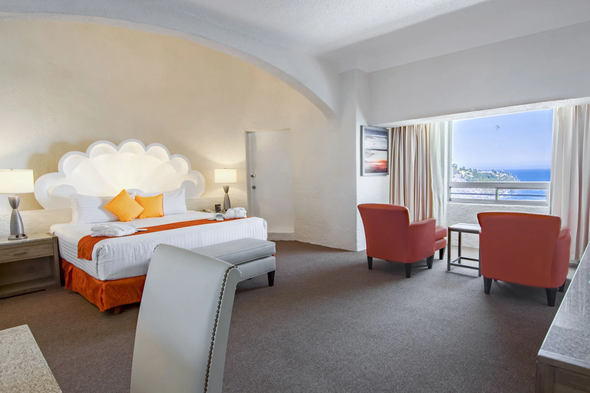Junior Room king bed and window seating with ocean view at Tesoro Manzanillo.