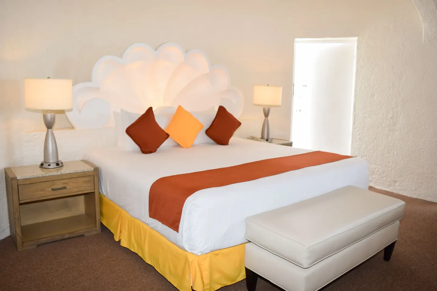 Junior Room king bed with shell headboard and bench at Tesoro Manzanillo.