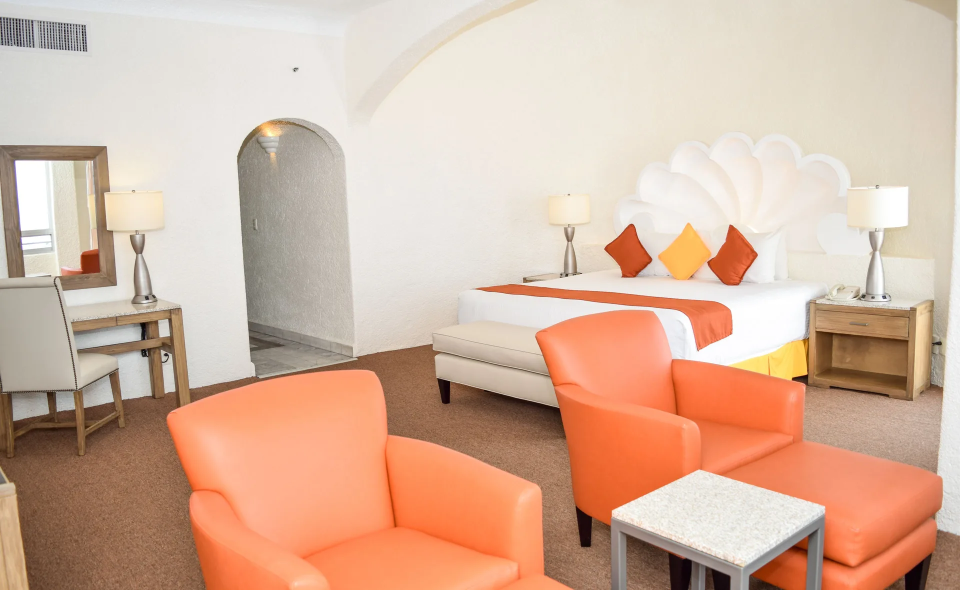 Junior Room king bed with sitting area and vanity at Tesoro Manzanillo.