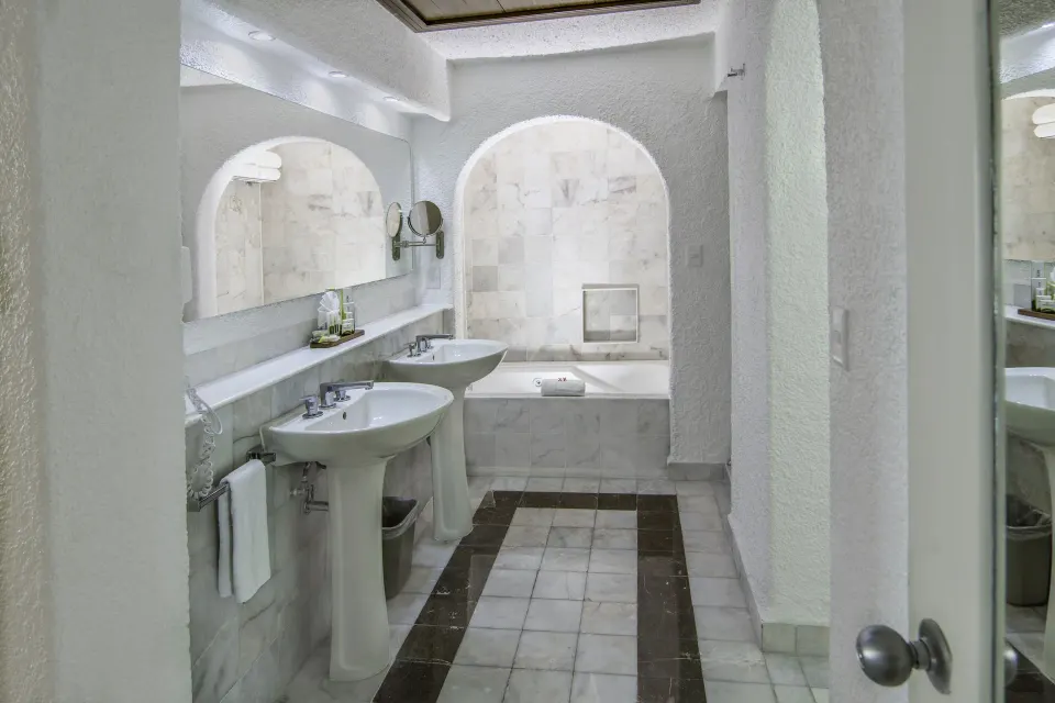 Master Suite bathroom with double pedestal sinks and bathtub at Tesoro Manzanillo.