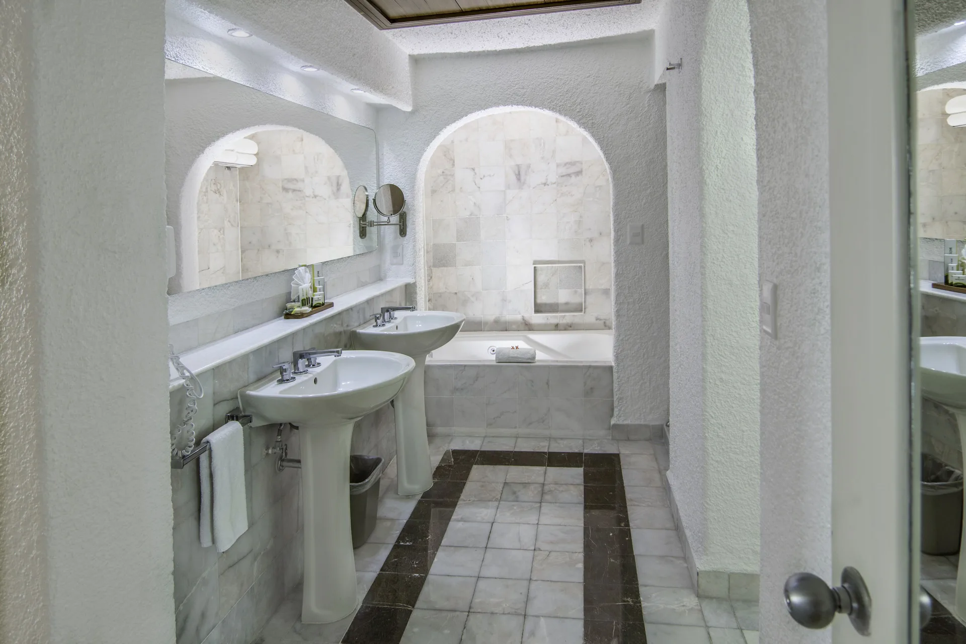 Master Suite bathroom with double pedestal sinks and bathtub at Tesoro Manzanillo.