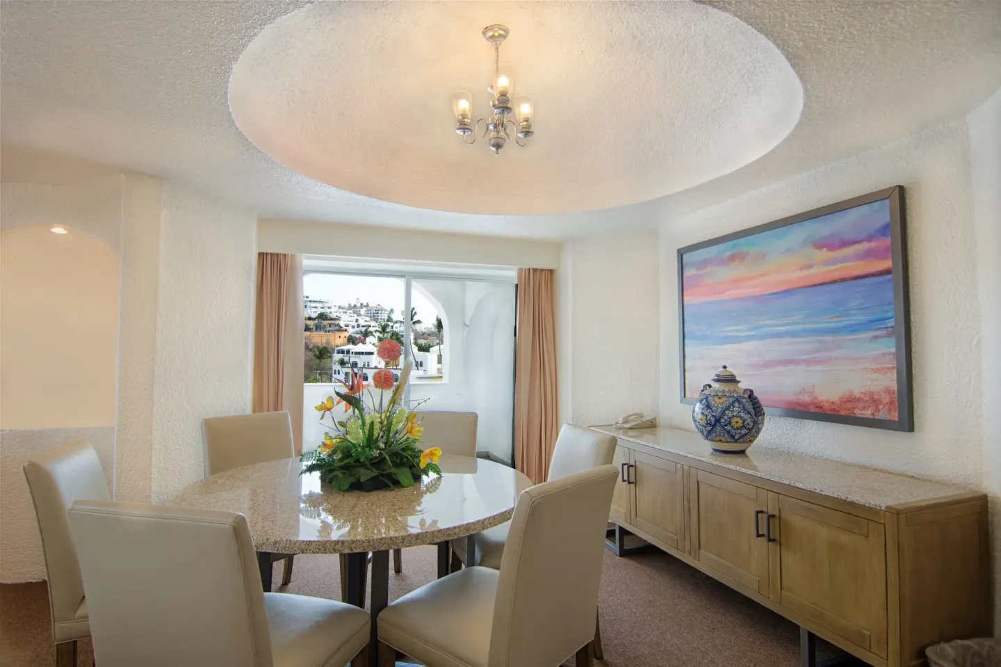Master Suite dining area with round table and artwork at Tesoro Manzanillo.