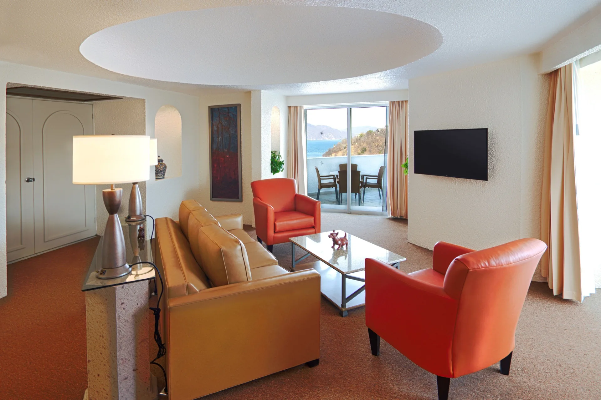Master Suite lounge with TV, balcony, and ocean view at Tesoro Manzanillo.