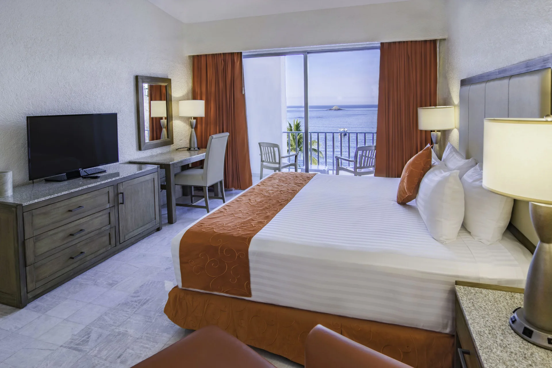 Standard Room Ocean View with king bed, TV, and balcony at Tesoro Manzanillo.