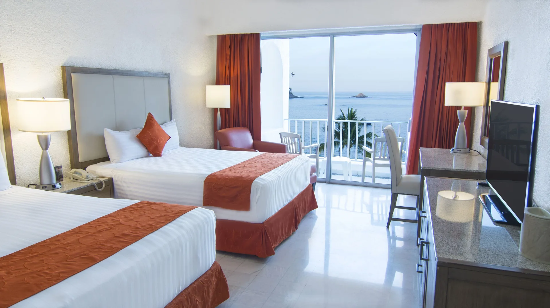 Standard Room Ocean View with two beds and red curtains at Tesoro Manzanillo.